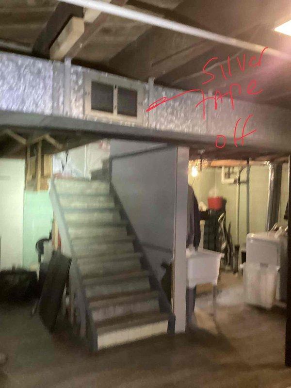Conducted furnace replacement estimate for a 38-year-old heating unit located in an unfinished basement with exposed joists and concrete flooring. Documented existing equipment configuration, including proximity to water heater, copper plumbing lines, brick wall penetrations, and HVAC ductwork routing. Assessed basement access via wooden staircase and photographed mechanical room layout to determine optimal replacement equipment specifications and installation requirements.
