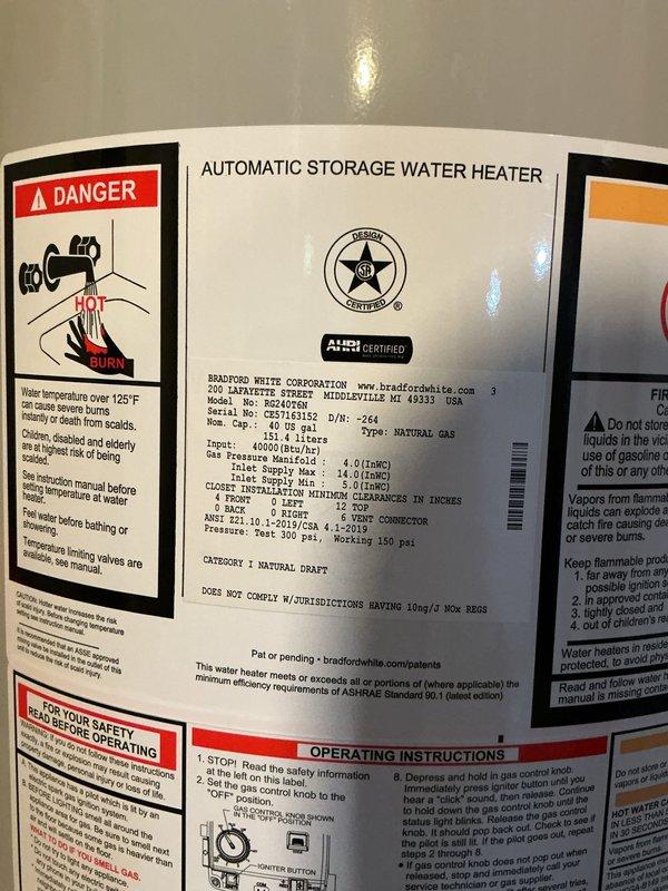 Installed Zoen System electronic control module on Bradford White 50-gallon natural gas water heater. Connected control wiring and network port to enable smart monitoring and diagnostic capabilities. Verified all plumbing connections, including metal pipe unions and fittings on cold water supply line. Confirmed proper installation of drain pan beneath unit and tested brass valve operation. Documented water heater specifications and safety label information for service records.
