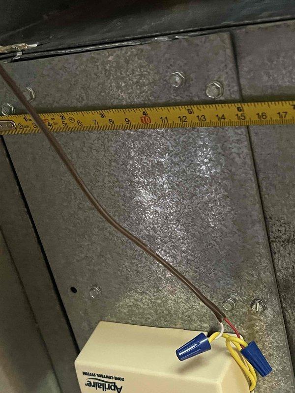 Responded to service call for uneven cooling with one side of house cold and other side warm. Inspected aging air conditioning system with outdoor condenser unit in backyard and furnace located in basement. Diagnosed zoning issue affecting temperature distribution throughout home. Measured and evaluated ductwork and damper positioning using precision measurements. Inspected Aprilaire control component and associated wiring connections within the HVAC system. Verified electrical connections and wire terminations at zone control panel. Assessed damper actuator functionality and mechanical operation. System tested after adjustments to restore balanced airflow and proper temperature control to all zones of residence.