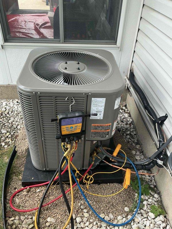 Completed installation of 2-ton air conditioning system with new evaporator coil connected to existing Lennox furnace in basement mechanical room. Installed outdoor condenser unit in rear yard on gravel pad with proper refrigerant line connections, performed system flush, and reconnected electrical service. Conducted startup procedures with manifold gauges to verify proper refrigerant charge, system pressures, and operational performance; all mechanical and electrical permits requested and system remeasured per specifications.