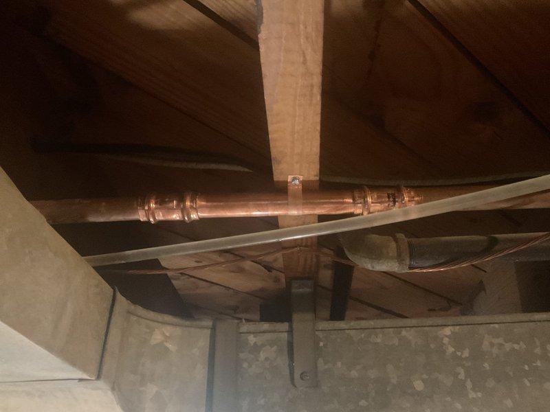 Responded to a water leak in the basement caused by a failing copper pipe joint. Upon inspection, identified significant corrosion and verdigris buildup on the compression fitting connecting two sections of copper water supply line. Removed the compromised fitting, cleaned the pipe ends, and installed a new compression coupling to restore a watertight seal. Tested the system under full pressure to confirm the leak was eliminated and verified proper water flow throughout the affected line.