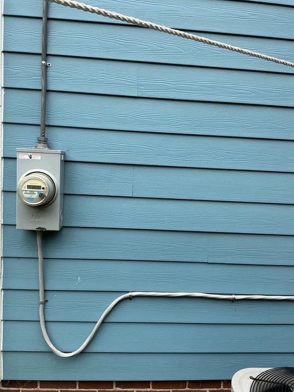 Conducted on-site evaluation for new whole home generator installation at manufactured home residence. Assessed existing electrical infrastructure including main service panel location in utility room and exterior meter base with overhead service entrance. Documented current electrical configuration, available space for generator placement, and determined requirements for automatic transfer switch integration with existing 200-amp service panel.
