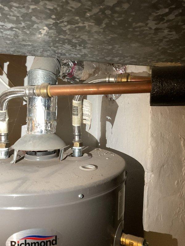 Performed comprehensive plumbing inspection of residential property to verify proper operation of all plumbing systems and components. Inspected Richmond-brand water heater installation including all supply and discharge connections, pressure relief valve, flexible stainless steel braided supply lines, and copper piping connections. Verified proper installation of all mounting hardware and fittings. Examined sump pump system including PVC discharge piping, pump mounting assembly, and sump pit operation. Assessed basement area for moisture conditions and proper drainage function. All plumbing systems found to be operating within normal parameters with no immediate repairs required at time of inspection.