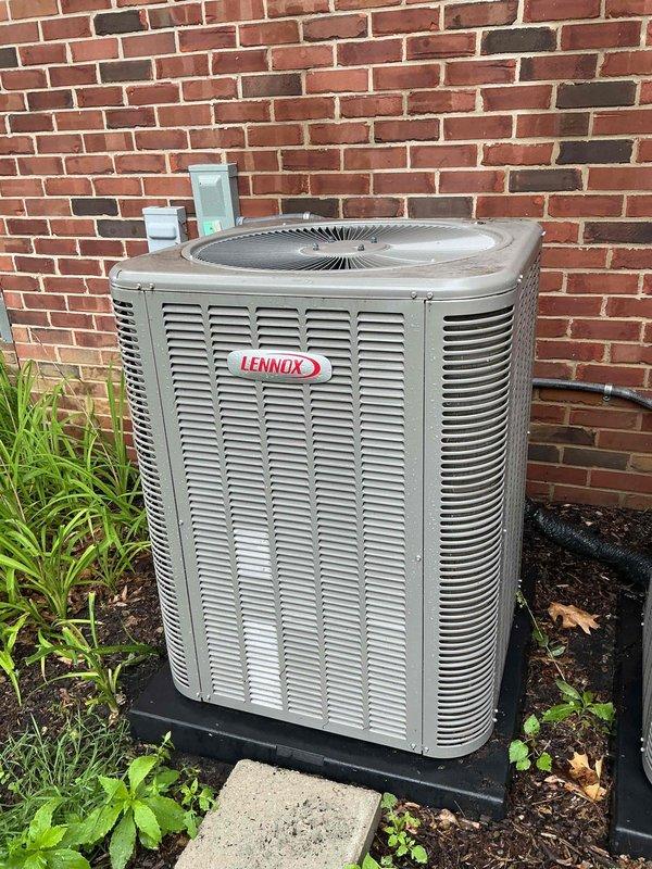Completed comprehensive Gold AC inspection on two Lennox air conditioning systems, approximately 5 years old, with air handler/coil located in basement. Performed full multi-point inspection of outdoor condenser units positioned against exterior brick wall, including visual assessment of cabinet condition, louver ventilation systems, and fan assemblies. Verified proper equipment operation, checked refrigerant levels, inspected electrical connections and disconnect boxes, examined condenser coil cleanliness, and assessed mounting pad stability. Both units found to be operational with normal wear consistent with age; documented equipment condition through photographic records showing exterior cabinet weathering and minor dirt accumulation on fan grills.