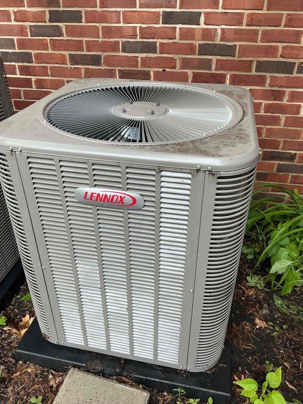 Completed comprehensive Gold AC inspection on two Lennox air conditioning systems, approximately 5 years old, with air handler/coil located in basement. Performed full multi-point inspection of outdoor condenser units positioned against exterior brick wall, including visual assessment of cabinet condition, louver ventilation systems, and fan assemblies. Verified proper equipment operation, checked refrigerant levels, inspected electrical connections and disconnect boxes, examined condenser coil cleanliness, and assessed mounting pad stability. Both units found to be operational with normal wear consistent with age; documented equipment condition through photographic records showing exterior cabinet weathering and minor dirt accumulation on fan grills.