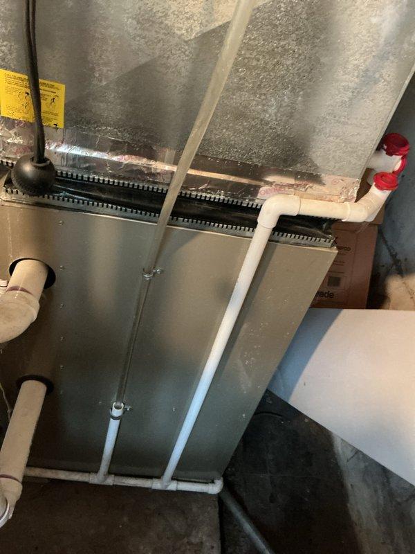 Completed Gold AC Inspection and maintenance on residential HVAC system with 12-year-old furnace located in basement. Upon inspection, discovered significant frost and ice accumulation on evaporator coil and ductwork in attic air handler, indicating restricted airflow or low refrigerant charge. Verified White-Rodgers programmable thermostat operation showing 69°F setpoint. Documented system conditions with photos showing extensive frost buildup on metal ductwork and air handler components, along with proper PVC condensate drain installation. System requires immediate attention to resolve freezing issue—likely causes include dirty evaporator coil, low refrigerant levels, inadequate airflow, or faulty expansion valve. Recommended follow-up service to diagnose root cause of icing condition, perform refrigerant charge verification, inspect blower motor operation, and clean evaporator coil as needed to restore proper system function and prevent compressor damage.