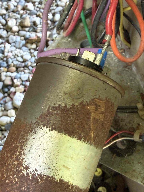Completed Gold AC Inspection on a single 10+ year old residential air conditioning system with air handler located in basement. Unit was operational at time of service. Performed comprehensive inspection of outdoor condensing unit, noting significant rust and corrosion on compressor housing exterior indicating prolonged weather exposure. Condenser coils were found heavily soiled with accumulated dirt, dust, and debris, requiring attention to maintain optimal heat transfer efficiency. Verified unit levelness and documented equipment condition through photographic records. Electrical connections at compressor terminal showed multiple color-coded conductors in place with visible terminal hardware. Equipment remains functional despite age-related deterioration of exterior components.