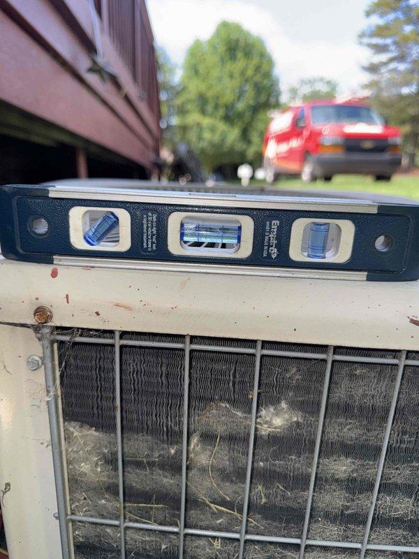 Completed Gold AC Inspection on a single 10+ year old residential air conditioning system with air handler located in basement. Unit was operational at time of service. Performed comprehensive inspection of outdoor condensing unit, noting significant rust and corrosion on compressor housing exterior indicating prolonged weather exposure. Condenser coils were found heavily soiled with accumulated dirt, dust, and debris, requiring attention to maintain optimal heat transfer efficiency. Verified unit levelness and documented equipment condition through photographic records. Electrical connections at compressor terminal showed multiple color-coded conductors in place with visible terminal hardware. Equipment remains functional despite age-related deterioration of exterior components.
