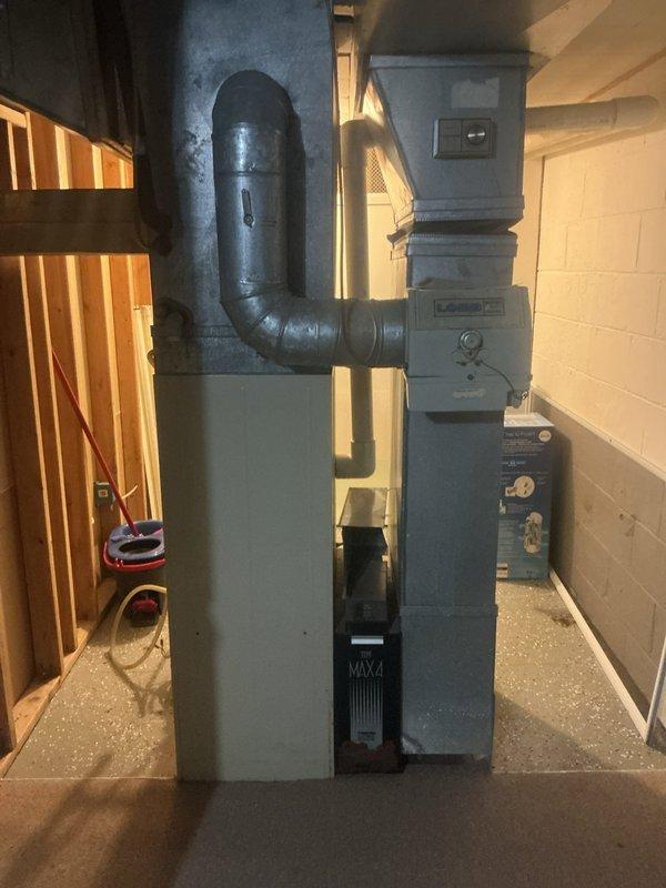 Responded to no cooling complaint on residential split system air conditioning unit. Upon arrival, found thermostat calling for cooling with indoor temperature reading 77°F and setpoint at 54°F, indicating system was running but not achieving temperature. Inspected furnace/air handler in basement and verified blower operation. Proceeded to outdoor condensing unit located behind residence and diagnosed complete refrigerant loss due to leak in system. System was unable to provide cooling capacity and required refrigerant recovery, leak detection, repair, and recharge to restore proper operation.