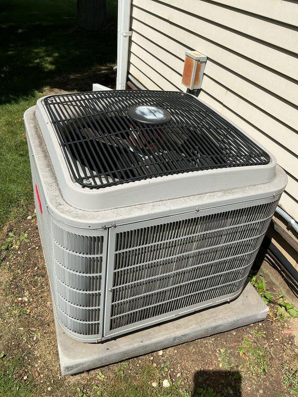 # HVAC Maintenance - Gold AC Inspection

Completed comprehensive Gold-level preventive maintenance inspection on residential air conditioning system. Exterior condenser unit positioned on concrete pad adjacent to home with white siding was thoroughly evaluated and serviced.

## Work Performed

Conducted complete visual inspection of outdoor condensing unit, verifying proper mounting on concrete pad and assessing overall unit condition. Cabinet showed normal wear consistent with outdoor exposure. Examined protective top grille and fan assembly, confirming structural integrity and proper clearances.

Performed detailed cleaning procedures on condenser coils using professional-grade equipment and cleaning solutions. Removed debris, dirt, and organic material from coil fins to restore optimal heat transfer efficiency. Flushed coils thoroughly to ensure complete removal of contaminants affecting system performance.

Inspected electrical components including disconnect box mounted on exterio