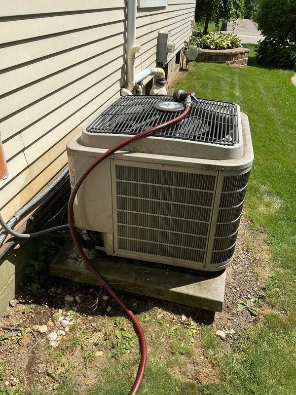 # HVAC Maintenance - Gold AC Inspection

Completed comprehensive Gold-level preventive maintenance inspection on residential air conditioning system. Exterior condenser unit positioned on concrete pad adjacent to home with white siding was thoroughly evaluated and serviced.

## Work Performed

Conducted complete visual inspection of outdoor condensing unit, verifying proper mounting on concrete pad and assessing overall unit condition. Cabinet showed normal wear consistent with outdoor exposure. Examined protective top grille and fan assembly, confirming structural integrity and proper clearances.

Performed detailed cleaning procedures on condenser coils using professional-grade equipment and cleaning solutions. Removed debris, dirt, and organic material from coil fins to restore optimal heat transfer efficiency. Flushed coils thoroughly to ensure complete removal of contaminants affecting system performance.

Inspected electrical components including disconnect box mounted on exterio