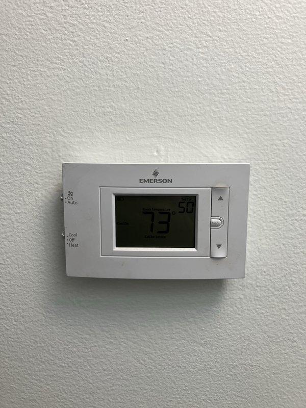 Responded to cooling system blowing hot air with continuous operation and no cooling. Upon arrival, diagnosed system with low refrigerant charge. Evaluated existing air conditioning equipment age and condition, inspected outdoor unit located behind house, reviewed thermostat operation showing 73°F current temperature, and assessed electrical panel configuration. Provided comprehensive estimate for complete HVAC system replacement due to system age and refrigerant loss, documenting equipment specifications and replacement recommendations for customer consideration.