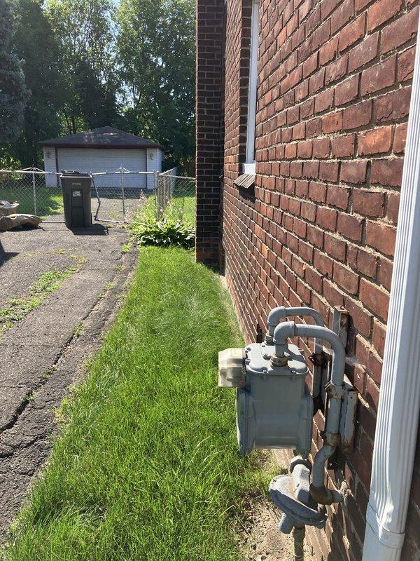 Conducted on-site assessment of existing HVAC equipment for replacement estimate at residential property. Evaluated exterior-mounted utility connections, electrical meter infrastructure, and current system configuration including fuel type determination and equipment accessibility along building exterior. Documented existing conditions with photographic evidence showing weathered meter equipment, drainage systems, and outdoor unit placement area adjacent to brick structure for proper sizing and installation planning of replacement system.