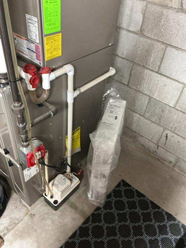Completed comprehensive Gold AC inspection on 10-year-old residential air conditioning system with air handler located in basement. Performed multi-point inspection including refrigerant level check, electrical component testing, condensate drain evaluation, and airflow assessment. Inspected furnace/air handler unit, associated PVC condensate piping with safety valves, and condensate pump operation. Verified system operational status, installed complimentary air filter, and documented equipment condition with photos. All components found functioning within normal parameters with no immediate repairs required.