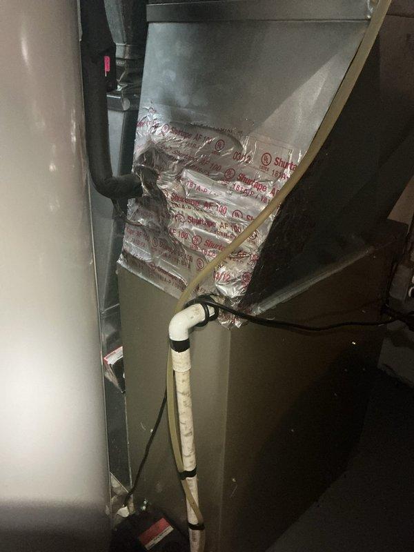 Responded to no cooling complaint on 10+ year old air conditioning system located in basement. Upon arrival, found thermostat not communicating with air handler unit. Inspected HVAC equipment including gray metal air handler and associated ductwork. Diagnosed communication failure between thermostat and system controls. Troubleshot electrical connections, control board, and wiring between thermostat and equipment. Verified power supply to unit and checked for loose connections at air handler. Restored proper communication between thermostat and system, confirmed cooling operation restored, and tested system functionality before departure.