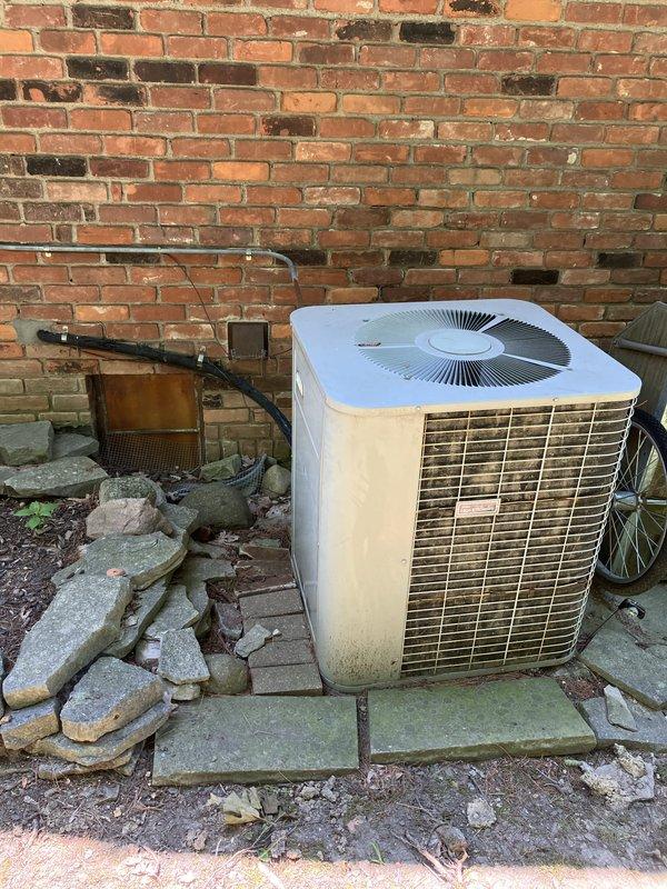 Responded to service call for air conditioning system not providing adequate cooling. Performed comprehensive evaluation of existing outdoor condensing unit located on right side of property, which showed significant age-related wear, discoloration, and dirt accumulation on cabinet surfaces. Documented current system condition through photographic assessment, noting weathered tan metal casing with horizontal louver ventilation grilles, aged concrete pad foundation, and associated electrical components including conduit and junction boxes mounted to brick exterior wall. Provided detailed replacement estimate options for complete system upgrade to address inadequate cooling performance and aging equipment concerns.