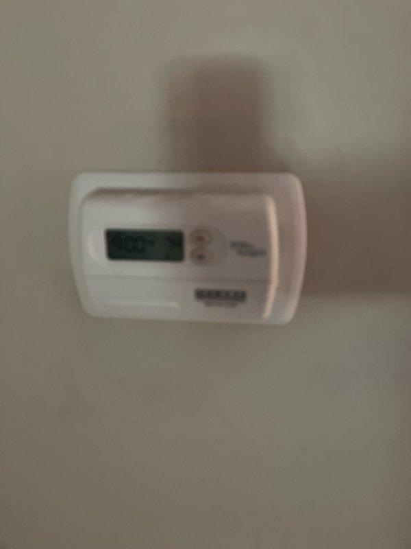Responded to service call for air conditioning system not cooling with non-functional compressor unit located in backyard. Performed comprehensive system evaluation including inspection of outdoor condensing unit, indoor furnace with evaporator coil, refrigerant line set, thermostat controls, and ductwork connections. Documented existing equipment condition through detailed photography of thermostat interface, furnace cabinet assembly, copper refrigerant piping with service valves, and associated HVAC components. Provided estimate for complete system replacement due to compressor failure and age of existing equipment.