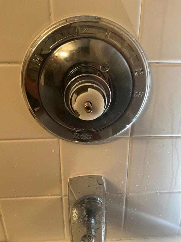 Responded to service call for malfunctioning hot/cold water regulator in shower/tub fixture. Upon inspection, examined the shower control valve mounted on tiled wall and assessed the temperature mixing mechanism. The circular chrome valve assembly with hot/cold markings and central control stem was evaluated for proper operation. Inspected water heater and associated plumbing connections in basement utility area to ensure proper supply temperature and pressure to the fixture. Documented existing conditions of shower valve, tub spout, and water heating system components.