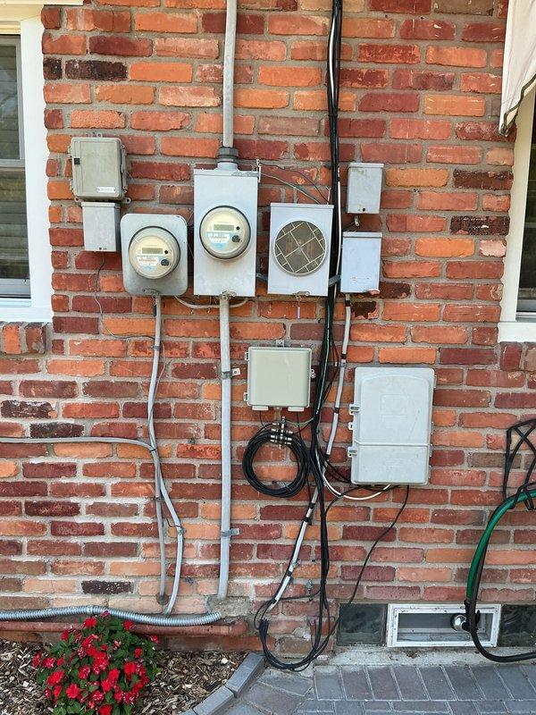 Completed generator replacement at residential property, removing existing Carrier 15kW unit from back patio location. Installed new standby generator system with associated electrical components, including transfer switch, circuit breaker panels, and meter connections mounted on exterior brick wall. Established proper conduit runs, wiring connections, and fuel lines to restore automatic backup power capability to home.