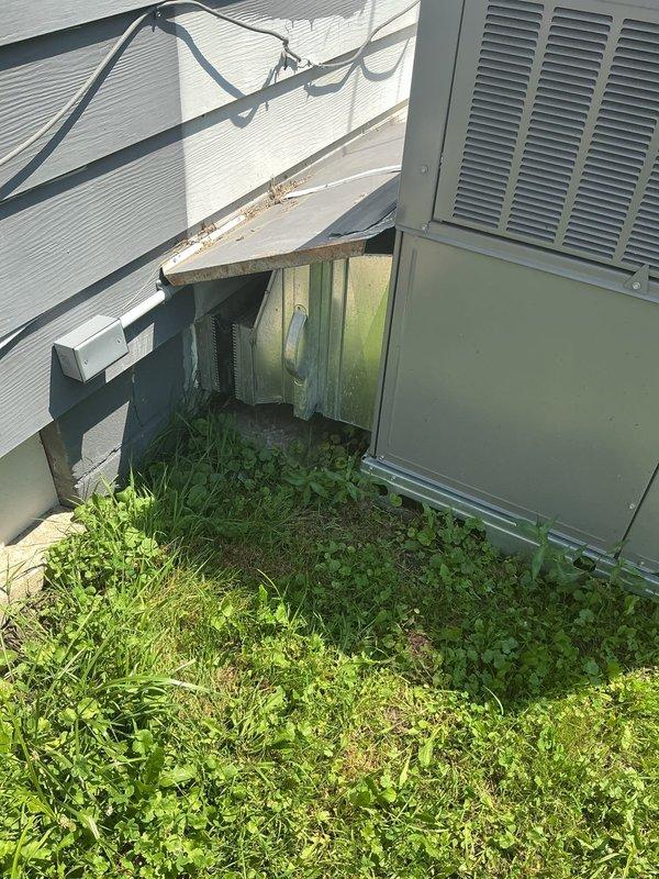 Responded to service call for inconsistent temperature control on 1-year-old residential AC unit located in backyard. Upon arrival, performed visual inspection of outdoor condensing unit and surrounding area. Unit appeared operational but site conditions revealed significant vegetation overgrowth around equipment and debris accumulation near installation, which can restrict airflow and reduce system efficiency. Documented equipment condition and installation environment with photographs. Recommended clearance of vegetation from around unit perimeter to ensure proper airflow and prevent potential performance issues that could contribute to temperature fluctuations throughout the day.