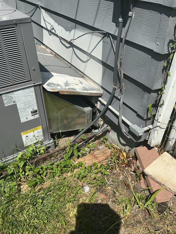 Responded to service call for inconsistent temperature control on 1-year-old residential AC unit located in backyard. Upon arrival, performed visual inspection of outdoor condensing unit and surrounding area. Unit appeared operational but site conditions revealed significant vegetation overgrowth around equipment and debris accumulation near installation, which can restrict airflow and reduce system efficiency. Documented equipment condition and installation environment with photographs. Recommended clearance of vegetation from around unit perimeter to ensure proper airflow and prevent potential performance issues that could contribute to temperature fluctuations throughout the day.
