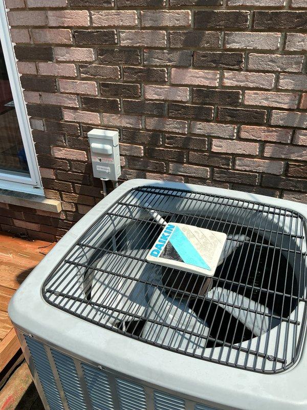 # HVAC Maintenance - Gold AC Inspection

Performed comprehensive Gold-level preventive maintenance inspection on a 5-year-old residential air conditioning system located on exterior wooden deck. System was reported to be operating without issues prior to scheduled maintenance visit.

## Work Performed

Conducted thorough visual inspection of outdoor condensing unit positioned against brick exterior wall. Verified unit accessibility and clearance requirements were adequate for proper airflow and service access. Inspected cabinet condition, noting protective grille cover in place on top of unit.

Performed detailed examination of refrigerant line set and associated components. Identified significant deterioration of black flexible duct material connected to system cabinet. Outer insulation jacket shows extensive damage with tearing, peeling, and separation from underlying structure throughout visible sections. Material degradation exposes inner duct layers and compromises thermal efficie