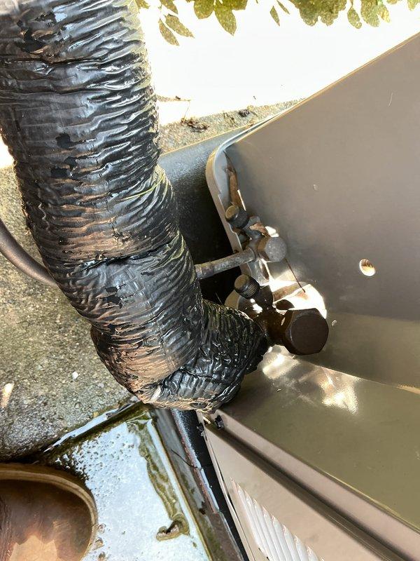 # HVAC Maintenance - Gold AC Inspection

Performed comprehensive Gold-level preventive maintenance inspection on a 5-year-old residential air conditioning system located on exterior wooden deck. System was reported to be operating without issues prior to scheduled maintenance visit.

## Work Performed

Conducted thorough visual inspection of outdoor condensing unit positioned against brick exterior wall. Verified unit accessibility and clearance requirements were adequate for proper airflow and service access. Inspected cabinet condition, noting protective grille cover in place on top of unit.

Performed detailed examination of refrigerant line set and associated components. Identified significant deterioration of black flexible duct material connected to system cabinet. Outer insulation jacket shows extensive damage with tearing, peeling, and separation from underlying structure throughout visible sections. Material degradation exposes inner duct layers and compromises thermal efficie