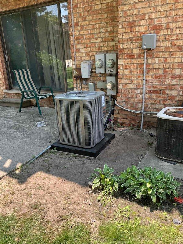 Completed installation of 2-ton air conditioning system with matching evaporator coil in rear yard location. Unit was positioned on pad against exterior brick wall near existing electrical meters, with all refrigerant lines, electrical connections, and condensate drainage properly installed and reconnected. Mechanical permit was requested for the installation, and system was tested for proper operation upon completion.