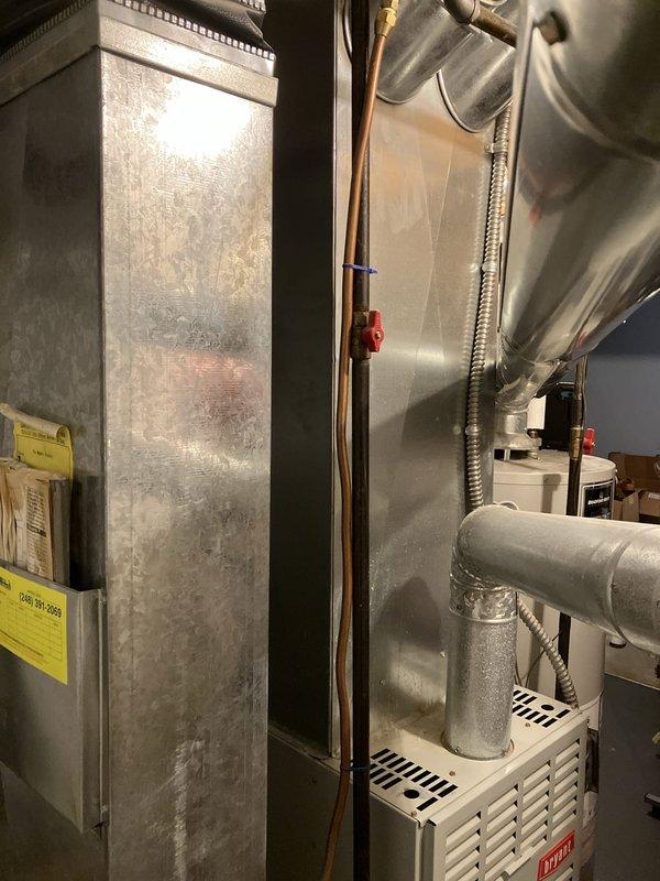 Conducted comprehensive replacement estimate for 26-year-old residential air conditioning system. Evaluated existing outdoor condensing unit located on patio and assessed indoor air handler equipment in basement mechanical room. Documented current system configuration including refrigerant line sets, ductwork connections, and electrical components. Photographed all major equipment including furnace, air handler, copper refrigerant lines, and supply ductwork to provide accurate sizing and replacement specifications for new cooling system installation.