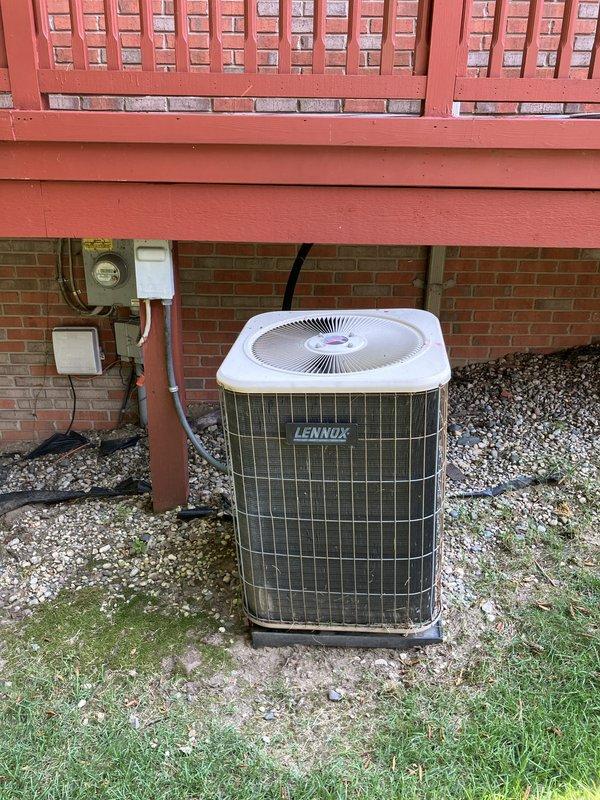 Conducted comprehensive gold-level air conditioning inspection on a 10+ year old Lennox R22 system with outdoor condenser unit located against building foundation beneath deck structure and air handler positioned in basement. Evaluated operational status of functioning equipment, documented existing system configuration including electrical components and drainage setup, and provided replacement estimate recommendations for aging R22 refrigerant system approaching end of service life.