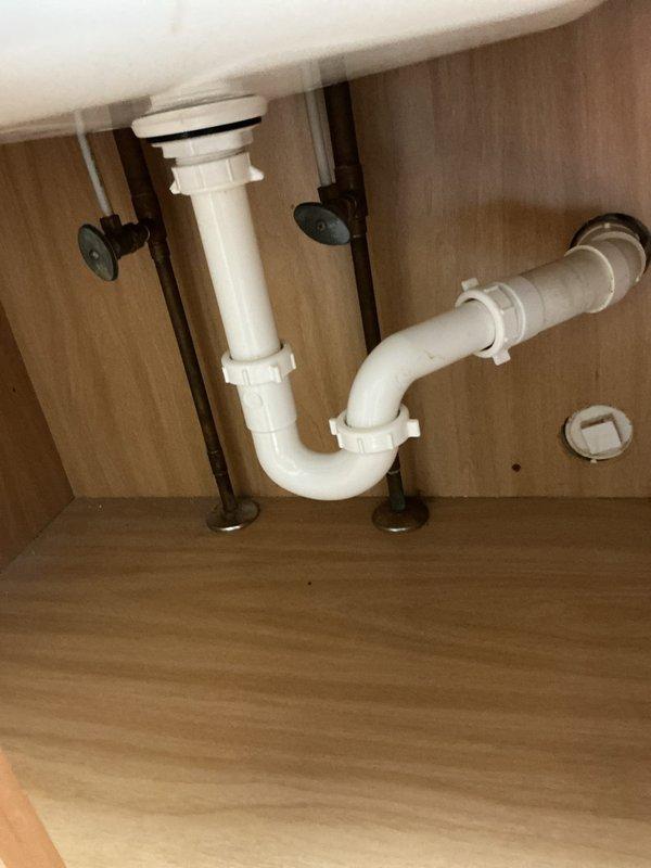 Installed and connected new laundry tub and dual-handle chrome faucet assembly. Completed all plumbing connections including P-trap installation with white PVC drain assembly, verified proper drainage function, and ensured all fixtures were securely mounted and leak-free.