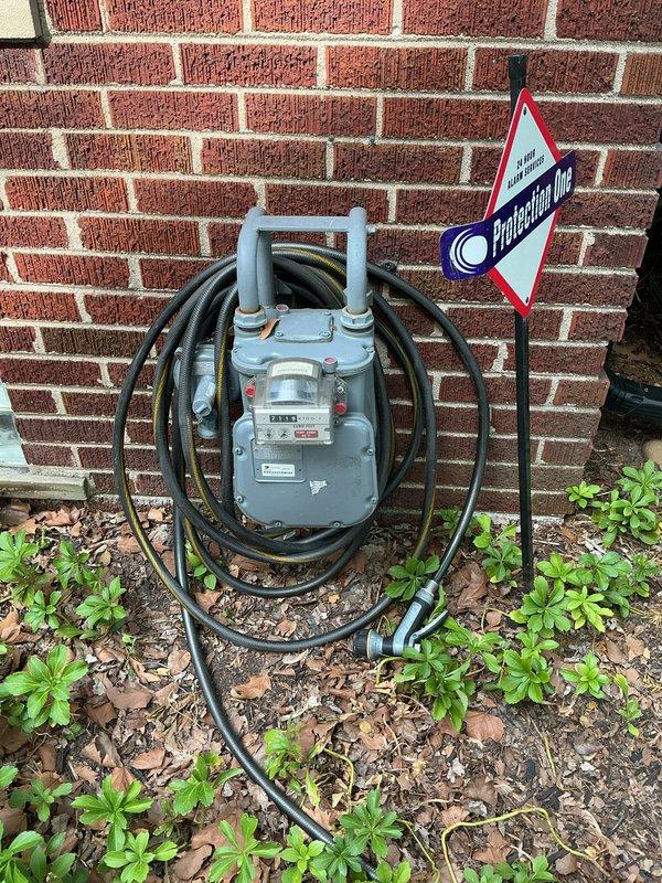 Conducted on-site evaluation for stand-alone electric generator installation at residential property. Assessed existing natural gas meter location and utility infrastructure along exterior brick wall foundation to determine optimal generator placement and fuel source connection. Evaluated backyard patio area and available space for generator pad installation, considering clearance requirements from structure, landscaping, and outdoor living areas. Documented site conditions through photographs to support equipment sizing recommendations and installation planning. Identified natural gas service as available fuel source for permanent standby generator system.