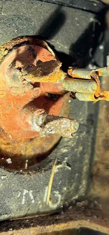Responded to no-cooling complaint on 25-year-old residential AC system. Upon inspection, found compressor unit completely inoperative with extensive corrosion throughout electrical connections and refrigerant line components. Outdoor unit exhibited severe rust deterioration on compressor housing, electrical terminals, and service valve assemblies, indicating prolonged moisture exposure and end-of-service-life condition. Electrical connections showed compromised integrity with corroded terminals and mounting brackets. Refrigerant line coupling displayed advanced oxidation with structural degradation. Documented equipment condition with photographs showing rust damage to compressor electrical components, service valves, and connection points. Given the age of the system and extent of corrosion damage, recommended full system replacement rather than repair due to safety concerns and likelihood of additional component failures. Customer was unavailable after 1 PM as noted, so findings and 