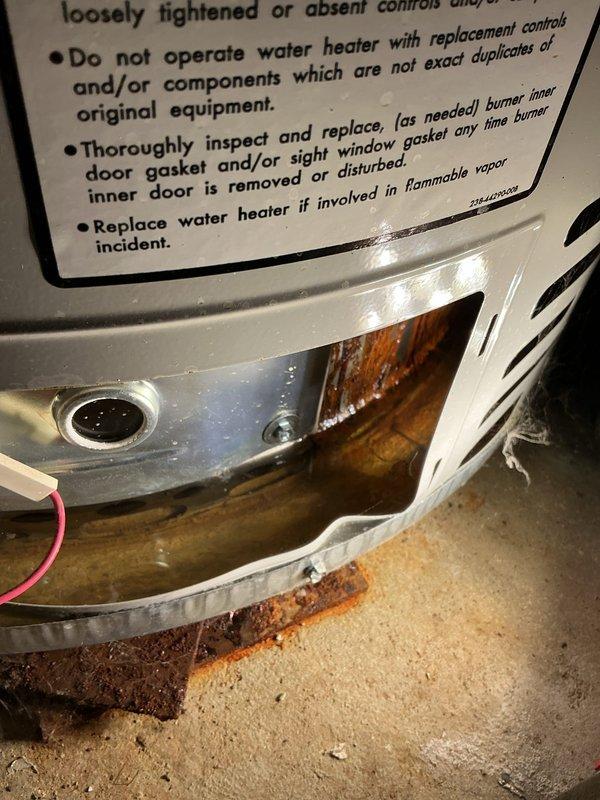 Responded to service call for gas-fired water heater not producing hot water. Upon arrival, performed diagnostic inspection of 6-year-old residential tank-style water heater still under manufacturer's 10-year warranty. Visual examination revealed extensive rust corrosion and deterioration around the burner assembly and base of the unit, indicating prolonged moisture exposure and potential tank failure. Rust staining was present on the concrete floor surrounding the water heater base, suggesting active or recent leaking. Inspected all plumbing connections, temperature and pressure relief valve, gas supply line, and exhaust venting system. Documented the severe corrosion damage with photographs showing compromised structural integrity at the tank base and burner compartment. Based on the extent of rust damage and loss of hot water functionality, determined that the unit requires warranty replacement rather than repair. Advised homeowner that the corrosion pattern indicates the tank has l