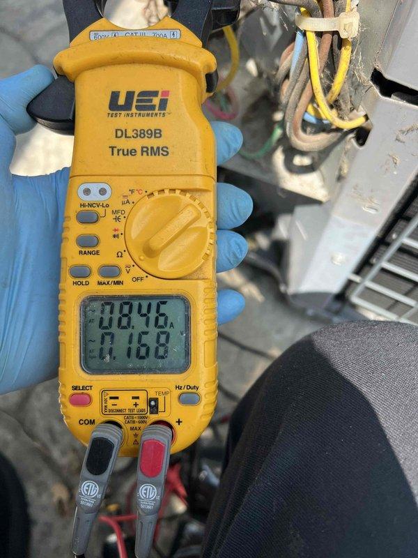 Responded to no cooling call on 10-year-old air conditioning system affecting entire home. Found indoor blower motor operating but no cooling output. Performed diagnostic testing at outdoor condensing unit located at rear of property using digital multimeter and clamp meter to measure voltage and amperage at compressor and associated electrical components. Readings indicated electrical supply issues or compressor failure preventing proper system operation. Documented findings with electrical measurements and provided customer with diagnostic results and repair options for the aging system.