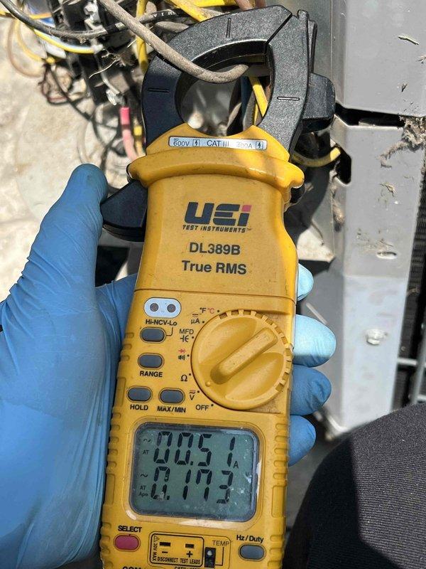 Responded to no cooling call on 10-year-old air conditioning system affecting entire home. Found indoor blower motor operating but no cooling output. Performed diagnostic testing at outdoor condensing unit located at rear of property using digital multimeter and clamp meter to measure voltage and amperage at compressor and associated electrical components. Readings indicated electrical supply issues or compressor failure preventing proper system operation. Documented findings with electrical measurements and provided customer with diagnostic results and repair options for the aging system.