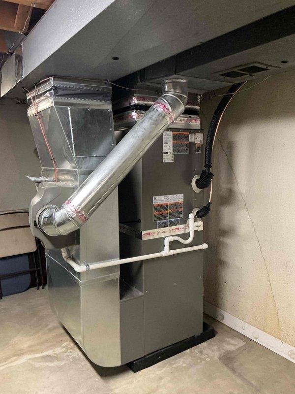 Completed installation of 3-ton Lennox air conditioning system with matching evaporator coil. Indoor coil was installed on existing furnace in basement utility area with proper refrigerant line connections, condensate drainage via PVC piping, and metal ductwork integration to existing plenum. Outdoor condensing unit was positioned on equipment pad in rear of property against brick wall structure with proper clearances maintained. Refrigerant lines were run and connected between indoor and outdoor components, system was evacuated, charged to manufacturer specifications, and tested for proper operation. All electrical connections were completed and reconnected per code requirements. System startup confirmed proper airflow, temperature split, and operational parameters within acceptable ranges.