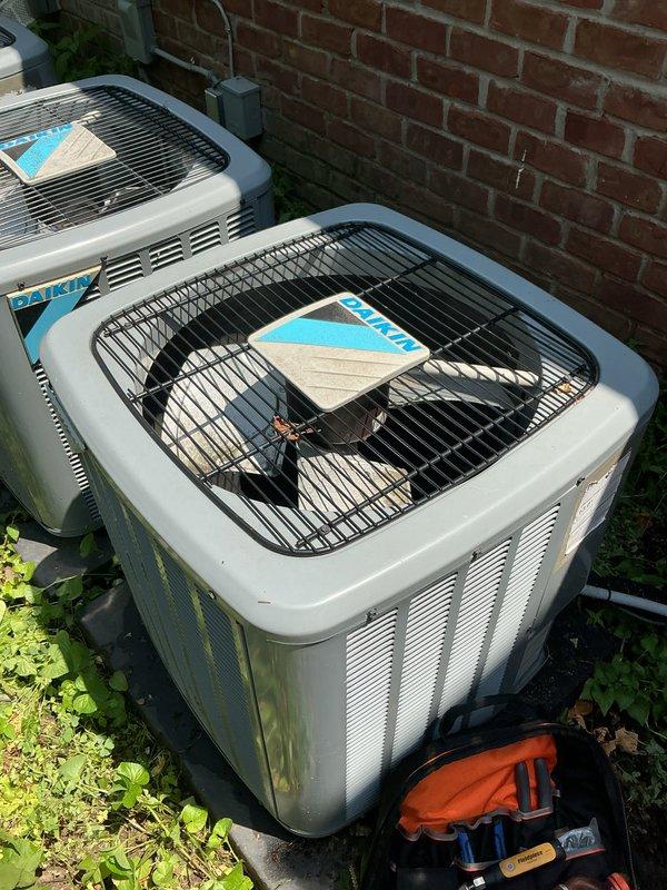 Completed comprehensive Gold AC inspection on multi-unit residential HVAC system with three 8-year-old air conditioning units and basement-located air handler. Performed thorough examination of outdoor Daikin condenser units, verified operational status of all equipment, inspected condenser coils and fan assemblies, checked refrigerant line connections, and assessed overall system performance. All units found to be operating within normal parameters with no immediate service concerns identified.