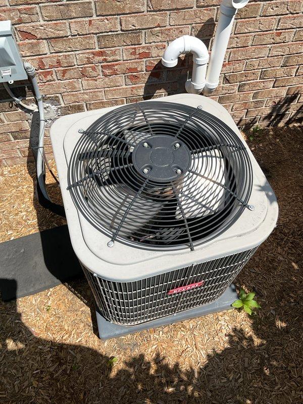 Completed comprehensive Gold AC Inspection on a five-year-old air conditioning system located in the basement. Performed full system evaluation including inspection of the outdoor condenser unit, verified proper operation of the condenser fan motor and blades, checked refrigerant levels, examined electrical connections at the disconnect box, and assessed the condition of condenser coils through the protective grille. Inspected PVC condensate drain line routing along the exterior brick wall for proper drainage and confirmed unit was level on concrete pad. All components found to be operating within normal parameters with no issues identified during the routine maintenance visit.