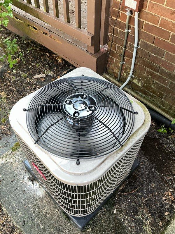 Completed Gold AC Inspection on 3-year-old residential air conditioning system. Performed comprehensive inspection of outdoor condenser unit positioned against exterior brick wall, verifying proper operation of fan motor assembly and protective grille. Inspected basement coil location and evaluated overall system performance. Unit found to be in functional condition with normal weathering consistent with outdoor exposure. Confirmed all components operating within manufacturer specifications with no immediate service concerns identified.