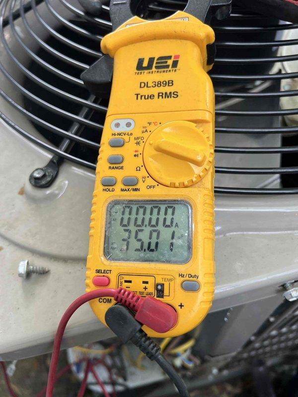 Responded to cooling complaint on 11-year-old basement air conditioning unit. Upon arrival, confirmed system was running but failing to adequately cool the space. Performed diagnostic testing using digital multimeter to measure electrical values and system performance parameters. Readings indicated abnormal operating conditions affecting cooling capacity. Documented system measurements and captured photographic evidence of diagnostic process for service records.