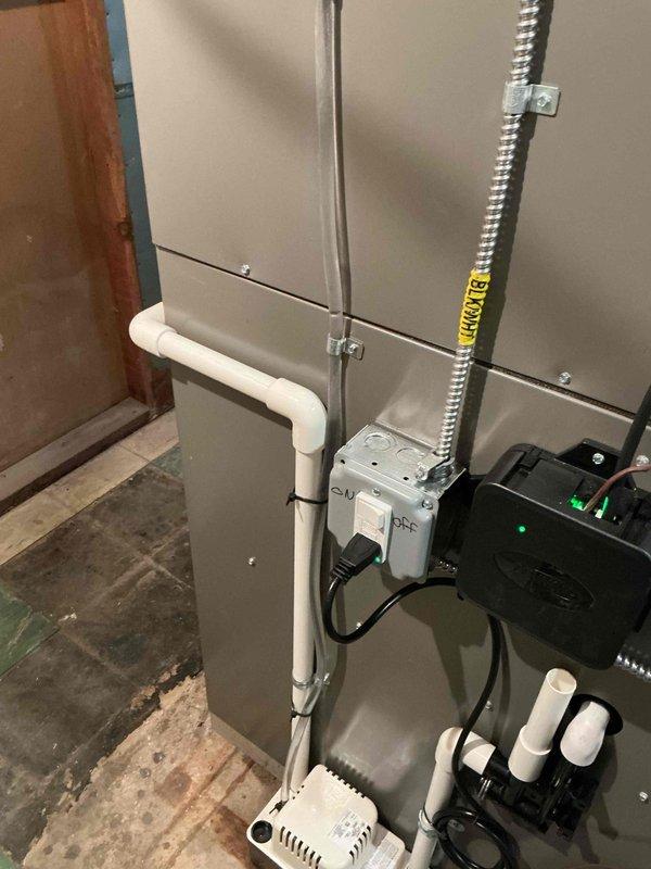 Completed comprehensive Gold AC inspection on a 1-year-old HVAC system with air handler located in basement. System is operational and functioning properly. Performed detailed multi-point inspection including examination of air handler unit, electrical connections, condensate drainage system with PVC piping configuration, flexible metallic conduit runs, and associated mechanical components. Verified proper installation of all system components, checked control box operation with illuminated indicator confirming power supply, inspected mounting and securing of all conduits and piping, and documented system condition through photographic records. All equipment found to be in good working order with no immediate service needs identified.