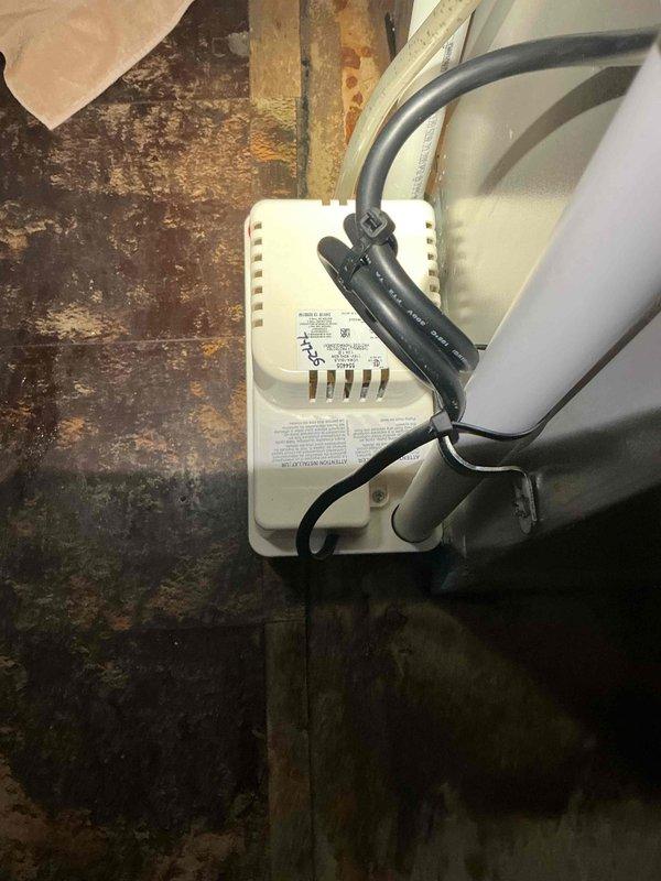# HVAC Service Call - Cooling Performance Issue

Responded to customer complaint regarding inadequate cooling performance with system running but not achieving desired temperature setpoints. Upon arrival, conducted comprehensive system evaluation to diagnose the cooling deficiency reported by customer who suspected thermostat malfunction.

Performed visual inspection of HVAC equipment revealing significant environmental concerns affecting system operation. Documented extensive rust and corrosion on metal surfaces surrounding control components and transformer unit, indicating prolonged moisture exposure in mechanical area. Observed active water infiltration issues in basement utility space with substantial floor staining and discoloration on concrete surfaces. Noted condensate pump system in operation with moisture management materials deployed on floor, confirming ongoing water accumulation problems in equipment area.

Inspected electrical connections, control wiring, and thermostat c