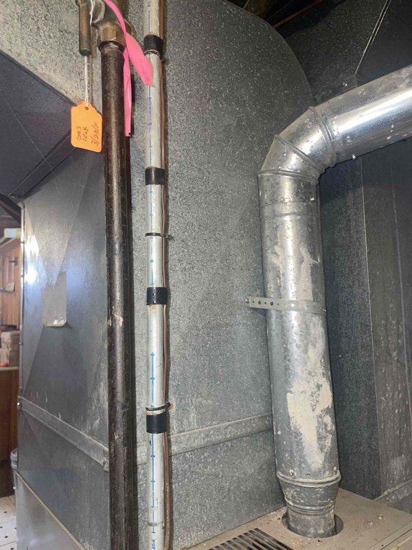 Conducted comprehensive site assessment for complete HVAC system replacement in 1,135 square foot residential property. Evaluated existing basement mechanical room configuration, including current furnace, ductwork, electrical service, and ventilation infrastructure. Documented existing equipment layout, noting gray metal furnace unit with connected PVC venting system, galvanized supply ductwork with visible aging and wear, electrical panel capacity and location, and concrete block foundation conditions. Assessed spatial requirements for new furnace and air conditioning system installation, verifying adequate clearances for equipment placement, service access, and code compliance. Photographed current mechanical room setup to support equipment sizing calculations and installation planning for proposed heating and cooling system upgrade.