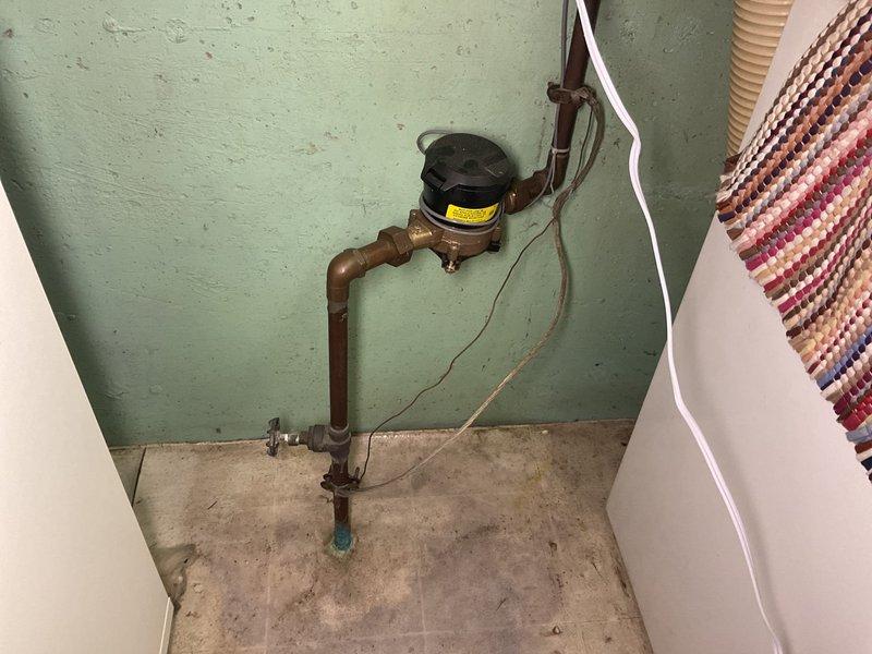 Responded to service call at 60+ year-old residence for evaluation of stiff main water shutoff valve and malfunctioning exterior faucet. Inspected main shutoff valve assembly located near pump in basement utility area, finding aged copper piping with significant patina and compromised valve operation due to internal corrosion and mineral buildup. Valve demonstrated restricted range of motion and failed to achieve complete shutoff position, presenting potential emergency water control concerns. Documented condition of existing plumbing infrastructure including water meter assembly and pipe connections. Assessed exterior faucet for repair feasibility, noting ongoing operational issues. Provided homeowner with professional recommendations regarding main shutoff valve replacement priority given age of installation and current failure to function as designed. Captured photographic documentation of existing conditions for service records and future reference.