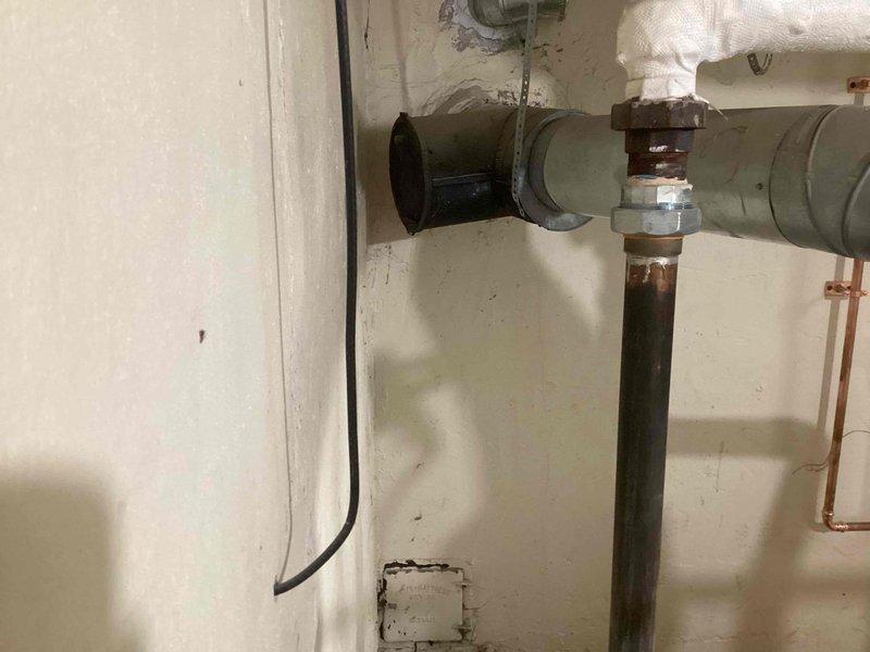 Responded to service call for leaking boiler pipes in basement on 10+ year old system. Upon inspection, identified active corrosion and rust deterioration at pipe coupling connections on vertical supply lines, with visible moisture damage and staining on surrounding ceiling areas. Documented existing conditions including compromised pipe insulation, corroded metal fittings, and aging infrastructure requiring immediate attention to prevent further water damage and system failure.