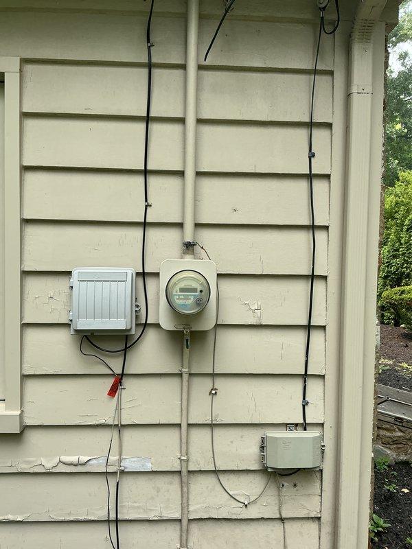 Conducted on-site assessment for Kohler generator installation estimate at residential property. Evaluated existing utility infrastructure including natural gas service with green gas meter, galvanized steel piping, electrical service panel with digital meter, and exterior mounting locations on lap siding. Documented current electrical and gas configurations, photographed utility connections, meter locations, and wall-mounted equipment to develop comprehensive replacement proposal for backup power generation system.