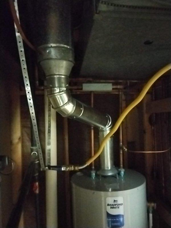 Responded to mechanical code violation requiring B-vent tee installation per MRC 2428.3.9.1. Installed compliant B-vent tee assembly on Bradford White water heater venting system in basement utility area. Reconfigured metallic vent piping with proper elbow joints and metal clamps to meet code requirements, ensuring proper draft and safe exhaust ventilation. Verified all connections secure and system operating within manufacturer specifications and local mechanical code standards.