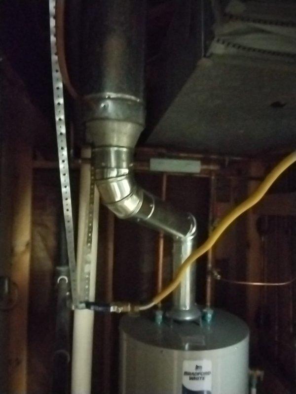 Responded to mechanical code violation requiring B-vent tee installation per MRC 2428.3.9.1. Installed compliant B-vent tee assembly on Bradford White water heater venting system in basement utility area. Reconfigured metallic vent piping with proper elbow joints and metal clamps to meet code requirements, ensuring proper draft and safe exhaust ventilation. Verified all connections secure and system operating within manufacturer specifications and local mechanical code standards.