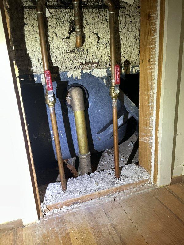 Responded to a slow, intermittent water leak in basement ceiling below bathroom in a 58-year-old home. Conducted thorough assessment of plumbing system, including inspection of vintage mint green bathtub with chrome fixtures and white tile surround. Accessed wall cavity to examine copper supply lines with brass fittings and shut-off valves, noting presence of aged spray foam insulation. Documented conditions with photographs showing plumbing infrastructure, drainage components, and water-damaged ceiling materials. Identified potential leak sources in bathroom plumbing system for further remediation recommendations.